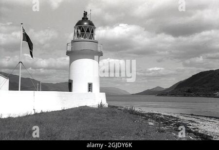 Anni '50, storico, il faro di Corran Point sulla riva di Loch Linnhe, Ardgour, vicino a Fort William negli altopiani scozzesi, Scozia, Regno Unito. Costruito nel 1857 dal padre e dallo zio di Robert Louis Stevenson, era uno dei fari che segnavano la strada per il canale Caledoniano. Foto Stock