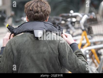 Un uomo che fissa il casco da bicicletta svedese Hovding (Hovding) che è un  airbag attivato in caso di collisione. Foto Fredrik Sandberg / TT code  10080 Foto stock - Alamy