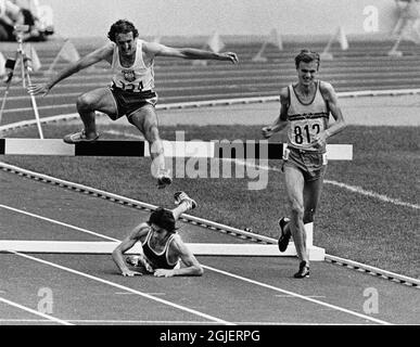 Anders Garderud sprinting per la medaglia d'oro in steeplechase di 3000 metri ai Giochi Olimpici di Montreal 1976. Baumgartl dalla Germania orientale è appena caduto sopra l'ultimo ostacolo e Malinowski dalla Polonia prende un salto sopra lui che corre per argento. Foto Stock