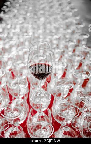 USA, Oregon, Portland. Un bicchiere di vino rosso su una fila di bicchieri vuoti. Foto Stock
