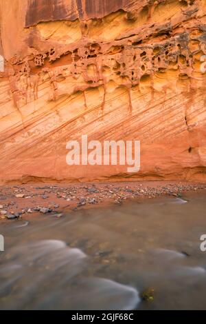 Stati Uniti d'America, Utah, parco nazionale di Capitol Reef, Fremont River e colorato, eroso la parete in pietra arenaria. Foto Stock