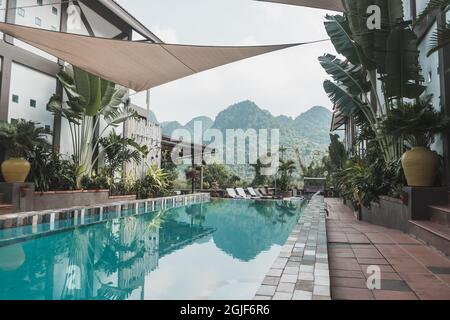 hotel boutique con piscina in Vietnam con vista sulle montagne. Acqua cristallina blu Foto Stock