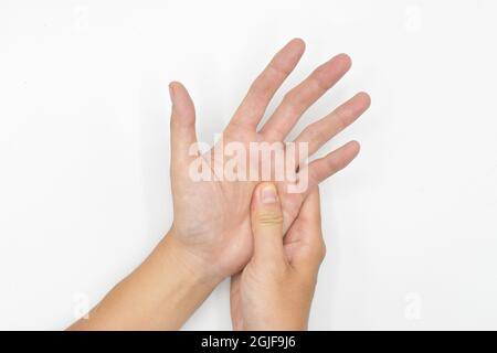 Massaggio a mano da parte del giovane asiatico. Dita e mano comune salute. Isolato su bianco. Foto Stock