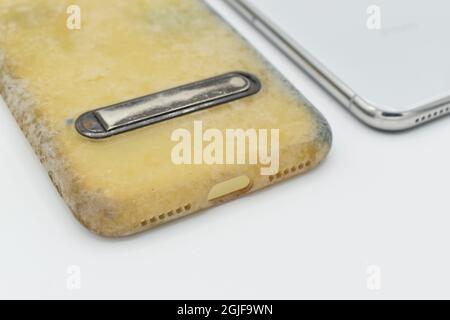 Custodia in silicone vecchia e sporca a causa di macchie e muffe gialle. Isolato su sfondo bianco. Primo piano. Foto Stock