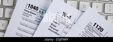 Documenti del modulo fiscale che si trovano sulla tastiera del computer closeup Foto Stock