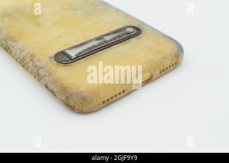 Custodia in silicone vecchia e sporca a causa di macchie e muffe gialle. Isolato su sfondo bianco. Primo piano. Foto Stock