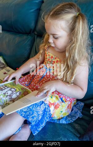 ragazza di 3 anni che legge libri a se stessa. (SIG.) Foto Stock