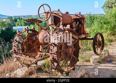 Un vecchio trattore arrugginito utilizzato in passato per i campi di riso Foto Stock