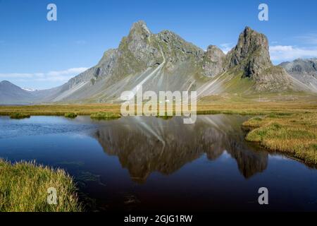 Montagna Vikurfjall riflessa su stagno, vicino Hvalnes Riserva Naturale, Islanda Foto Stock