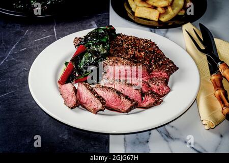 Rara bistecca con tutto il condimento del bagel servita con la zizzera rossa svizzera Foto Stock