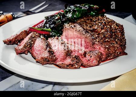 Rara bistecca con tutto il condimento del bagel servita con la zizzera rossa svizzera Foto Stock