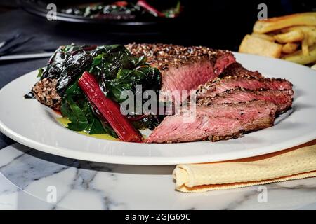 Rara bistecca con tutto il condimento del bagel servita con la zizzera rossa svizzera Foto Stock