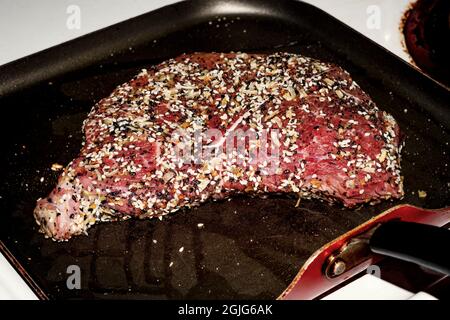 Bistecca da cucina con tutto il condimento del bagel sul piano cottura Foto Stock