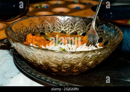 Giocare gioco da tavolo mancala mentre si mangia cibo indiano tra cui pollo tikka e pindi chana masala così come aloo matar Foto Stock