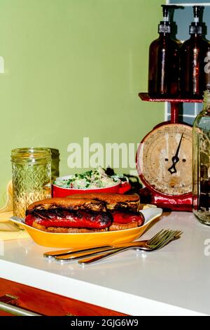 Sandwich secondario con salsiccia di kielbasa alla griglia con salsa di patate alla dea verde Foto Stock