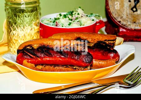 Sandwich secondario con salsiccia di kielbasa alla griglia con salsa di patate alla dea verde Foto Stock