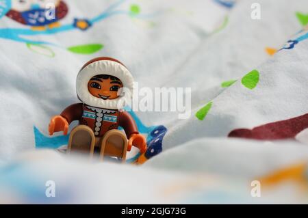 POZNAN, POLONIA - Lug 09, 2017: Statuetta LEGO eskimo seduta su una coperta morbida Foto Stock