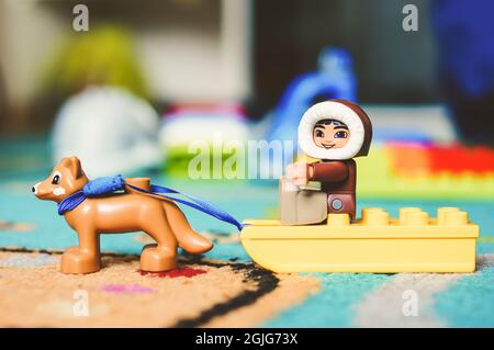 POZNAN, POLONIA - 19 feb 2017: LEGO Duplo giocattolo eskimo seduto su una slitta con il cane su un tappeto in morbido fuoco Foto Stock