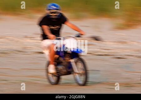 Adolescente in bicicletta motorizzata alla spiaggia Breezy Point Gateway NRA durante la stagione dei nesting Shorebird Foto Stock