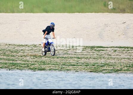 Adolescente in bicicletta motorizzata alla spiaggia Breezy Point Gateway NRA durante la stagione dei nesting Shorebird Foto Stock