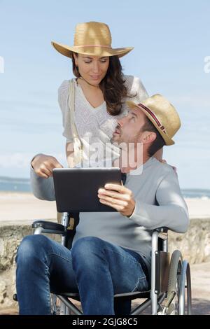 uomo disabile e la sua ragazza con tablet digitale Foto Stock