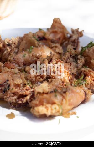 'Chipirones fritos' calamari fritti conditi con limone serviti su un piatto. Cucina spagnola. Foto Stock