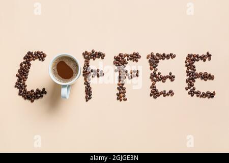 Tazza di gustoso caffè e caffè in grani su sfondo chiaro Foto Stock