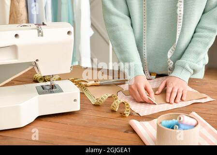 Giovane donna che lavora con il modello di cucito in studio Foto Stock
