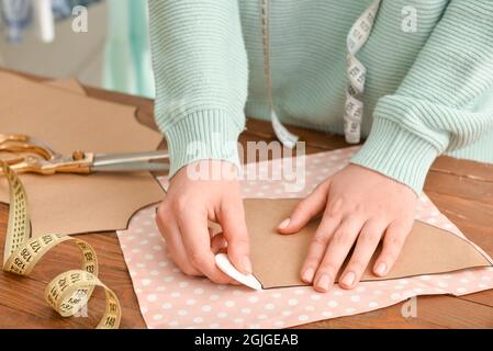 Giovane donna che lavora con il modello di cucito in studio Foto Stock