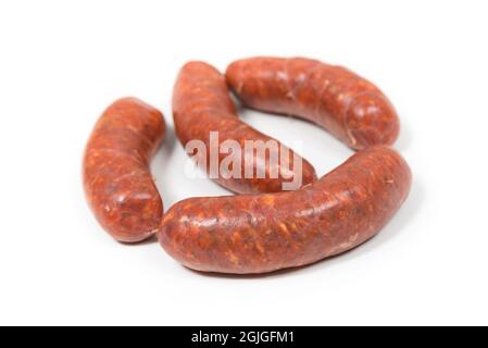 Quattro salsicce rosse di chorizo grezze su sfondo bianco Foto Stock