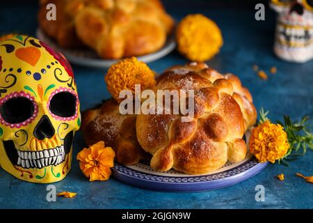 Pane dei morti e cranio dipinto su sfondo colorato. Celebrazione della Giornata dei morti del Messico (El dia de Muertos) Foto Stock