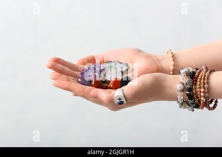 Mani femminili con belle gemme su sfondo chiaro Foto Stock