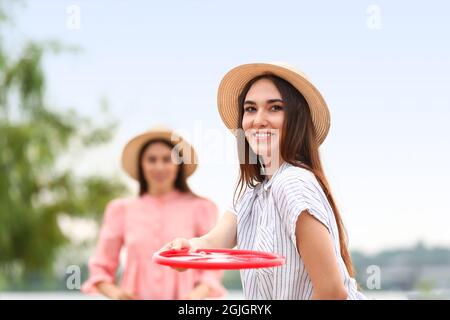 Belle giovani donne che giocano frisbee all'aperto Foto Stock