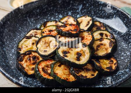 Piastra con gustose zucchine grigliate sulla tavola, primo piano Foto Stock