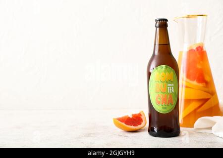 Bottiglia e caraffa di gustoso tè kombucha sul tavolo Foto Stock