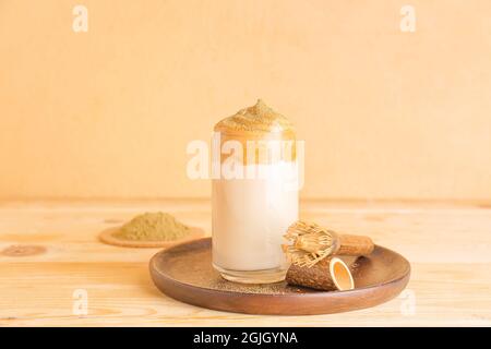 Bicchiere di gustoso dalgona hojicha latte e chasen sul tavolo Foto Stock