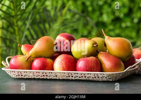 Vassoio con pere e mele mature sul tavolo all'aperto Foto Stock