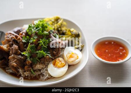 Primo piano di cibi deliziosi su un piatto con salsa sulla superficie di legno Foto Stock
