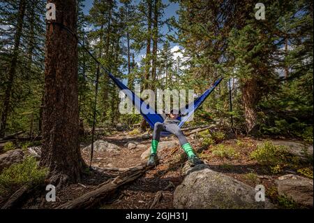 Uno zaino in spalla si rilassa su un'amaca in un campeggio nel Rocky Mountain National Park Colorado USA Foto Stock
