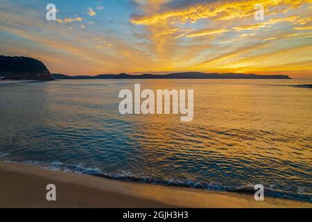 Alba al mare con cielo pieno di nuvole da Pearl Beach sulla costa centrale, NSW, Australia. Foto Stock