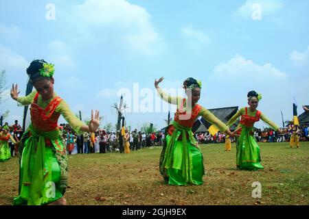 Le ragazze in abiti tradizionali ballano durante l'evento Seren Taun, un evento annuale dopo la stagione della raccolta del riso a Sindang Barang, Bogor, West Java. Foto Stock