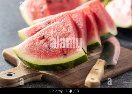 Cocomero a fette rosso. Pezzi di melone rosso sul tagliere. Foto Stock