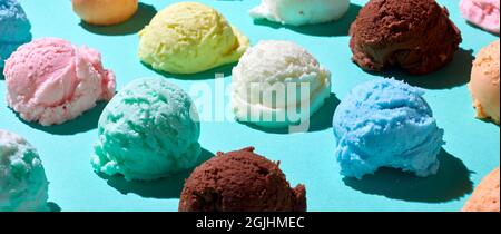Alto angolo di sfondo di colorate palline di gelato freddo poste in file su un tavolo blu Foto Stock