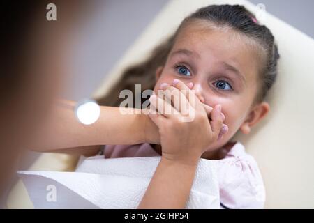 Bambino spaventato che visita dentista in clinica dentale Foto Stock