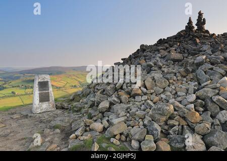 Rocce accatastate sopra un cairn e il punto di trig, sulla cima di Beamsley Beacon, una collina a Wharfedale, Yorkshire Dales National Park, Regno Unito Foto Stock