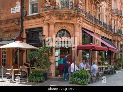 Persone sedute a tavoli da marciapiede che cenano all'aperto fuori Delfino Mayfair, una trattoria italiana a Mount Street, Mayfair, Londra, Inghilterra, Regno Unito Foto Stock
