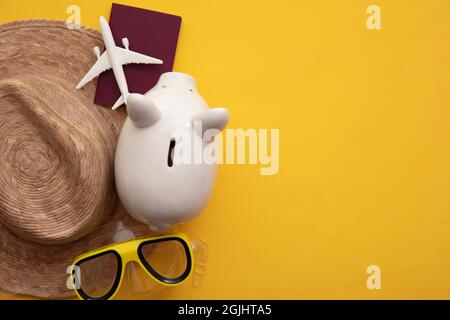 Risparmio per una vacanza estiva. Banca Piggy di denaro con accessori per le vacanze Foto Stock