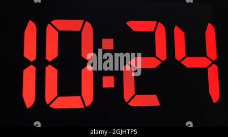 Primo piano di un orologio digitale con riproduzione in rosso che mostra l'ora 10:24 AM Foto Stock