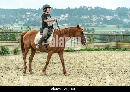 Ragazza cavalca un cavallo in una stalla. Lione, Francia, Europa Foto Stock