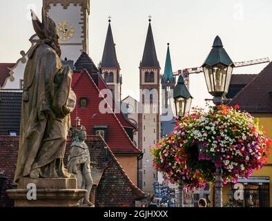 10 settembre 2021, Baviera, Würzburg: Le statue di santi (l) e lanterne sul Ponte Vecchio e la torre del Vecchio Municipio (l.o.) sono visivamente disegnate insieme alle torri della Cattedrale di San Kiliano (M) attraverso un lungo teleobiettivo. Foto: Frank Rumpenhorst/dpa Foto Stock